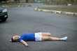 © Евгений Шемякин - Downed girl by car, young unconscious woman lying on road, asphault, suffering from pain, injury or trauma. Inattentive person, female was hit by careless driver. Accident on road. Dangerous situation