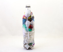 An Empty Plastic Bottle Filled With Discarded Single-use Plastic Litter To Make An Eco-brick Isolated On A Clear Background Image With Copy Space In Horizontal Format