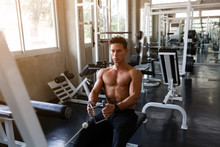 Handsome Muscular Man Doing Exercise And Pulling Weights In Seated Cable Row Machine, Athlete Makes Exercise, Bodybuilder, Sport Fitness And Muscles Concept