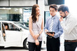 © artitwpd - Car Dealership. The Asian Salesman (woman and man) checking the list with the middle east customer before hand over. Automotive Leasing and Dealing Business. International Business.