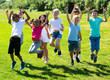 © JackF - Friendly kids jumping together in park on summer