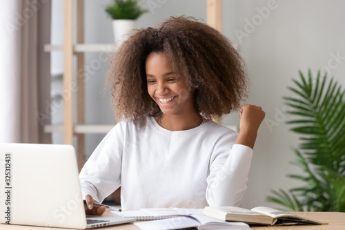 Fotografía Excited overjoyed african teen girl student winner looking at laptop