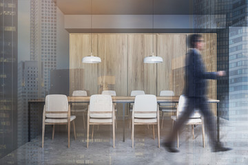 Wall Mural - Businessman walking in gray and wooden cafe