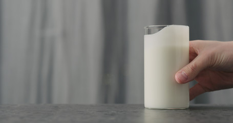 Wall Mural - man hand take glass with white yogurt on concrete countertop