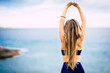 © simona - Healthy lifestyle people concept with beautiful long blonde hair girl viewed from back do some stretching in front of the ocean view outdoor - fit woman and attractive female