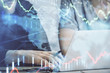 © peshkova - Forex graph with businessman typing on computer in office on background. Concept of analysis. Double exposure.