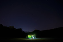 Vintage Motorhome On The Beach In Night Time. Dark Starry Sky With Shining Stars. Camper Lifestyle