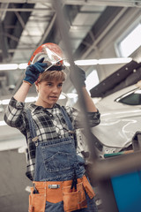 Female mechanic in work clothes staring forwar