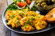 Breakfast - Scrambled Eggs With Vegetables And Toasted Bread On Wooden Background