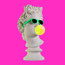 Statue On A Pink Background. Gypsum Statue Of Apollo Head. Man. Creative. Plaster Statue Of Apollo Head In Sunglasses. Minimal Concept Art.