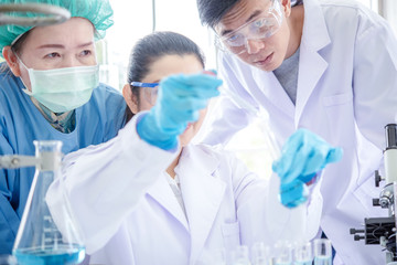 Wall Mural - laboratory research. team work asian people scientists analyzing study data and evaluating microscop