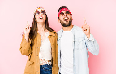 Wall Mural - Young caucasian couple wearing a music festival clothes isolated pointing upside with opened mouth.