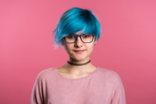 Portrait Of Young Punk Unusual Woman With Blue Hair On Pink Background. Girl In Transparent Glasses With Black Choker.