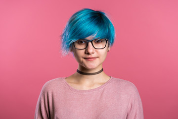 Portrait of young punk unusual woman with blue hair on pink background. Girl in transparent glasses with black choker.