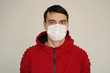 A man in a white medical mask in red clothes on a white background