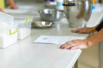 The cook is studying the recipe before cooking