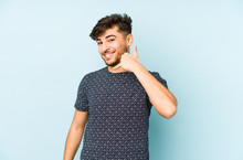 Young Arabian Man Isolated On A Blue Background Showing A Mobile Phone Call Gesture With Fingers.
