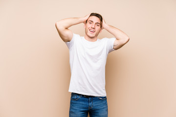 Wall Mural - Young caucasian man posing isolated laughs joyfully keeping hands on head. Happiness concept.