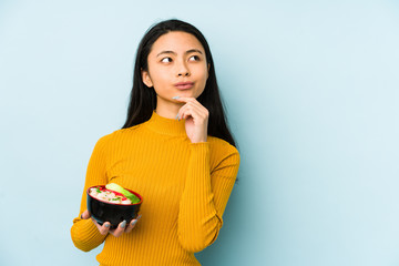 young chinese woman holding noodles isolated showing number one with finger.