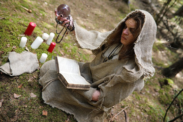 Wall Mural - A man in a cassock spends a ritual in a dark forest