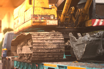 Digger tractor with claw on transport trailor ,closed up with sun light