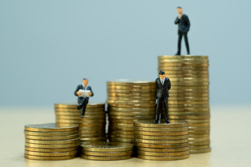 Successful businessman with business planning. Businessmen standing on stacks of golden coins.