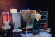 © Owl-vision-studio - A young female artist is creating an abstract painting. She is working in the loft space with dimmed lights. She is using oil paint and a brush.