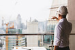 © Shutter B - Portrait engineer man wearing safety helmet standing back and looking to the construction site with modern city background. Industry, Engineering, construction concept. With copy space for your text.