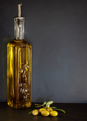 Wall Mural - Glass bottle of olive oil with olives and on olive branch.