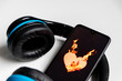 Blauer Funkkopfhörer mit schwarzem Smartphone und brennendem Herz zeigt die feurige Liebe zur Musik und mobilen Musikgenuss digitaler Unterhaltung