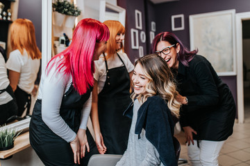 Beautiful hairstyle of young woman after dyeing hair and making highlights in hair salon.