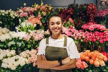 Woman Florist Standing In Flower Shop. Female Florist In Apron Standing With Her Arms Crossed.