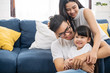 Portrait of happy Asian family spending time together on sofa in living room. family and home concept.