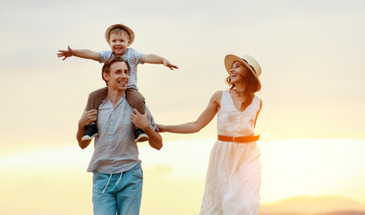 Happy family father of mother and child son  on nature at sunset.