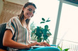 © Valerii Apetroaiei - Attractive young woman in glasses works at a laptop while sitting cross-legged in a comfortable chair at home.