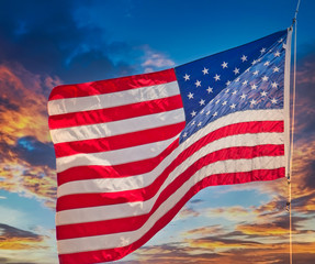 Wall Mural - An American flag waving in the wind against a blue sky