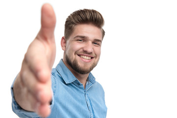 Canvas Print - Cheerful casual man smiling and reaching for a handshake