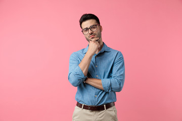 sexy young man holding hand to chin and thinking