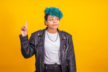 young modern brunette girl with curly blue hair of afro american ethnicity isolated on color background