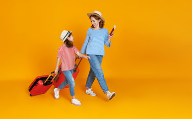 Wall Mural - happy journey! family of travelers mother and child  with suitcases tickets and passports on yellow background.