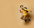 © FAB.1 - Portrait of a young student man jumping in the studio on a beige background