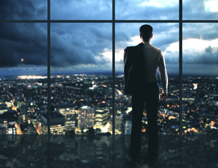 Wall Mural - Businessman standing in night offic