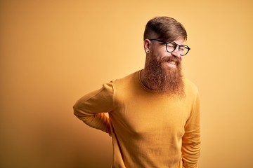 Sticker - Handsome Irish redhead man with beard wearing glasses over yellow isolated background Suffering of backache, touching back with hand, muscular pain