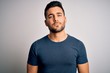 © Krakenimages.com - Young handsome man wearing casual t-shirt standing over isolated white background Relaxed with serious expression on face. Simple and natural looking at the camera.
