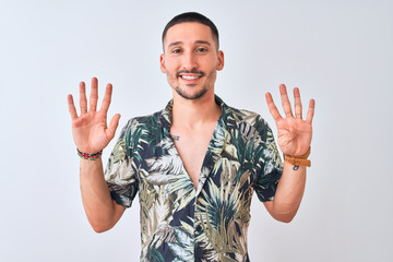 Wall Mural - Young handsome man wearing Hawaiian summer shirt over isolated background showing and pointing up with fingers number nine while smiling confident and happy.