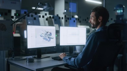 Fototapete - Industrial Engineer Solving Problems, Working on a Personal Computer, Two Monitor Screens Show CAD Software with 3D Prototype of Eco-Friendly Electric Engine Concept. Side Arc View
