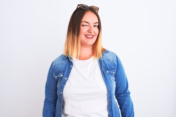 Sticker - Beautiful woman wearing denim shirt standing over isolated white background winking looking at the camera with sexy expression, cheerful and happy face.