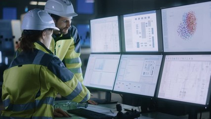 Leinwandbilder - Industry 4.0 Modern Factory: Project Engineer Talks to Female Operator who Controls Facility Production Line, Uses Computer with Screens Showing AI, Machine Learning Enhanced Assembly Process
