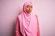 © Krakenimages.com - Young African American afro woman wearing muslim hijab over isolated pink background looking sleepy and tired, exhausted for fatigue and hangover, lazy eyes in the morning.