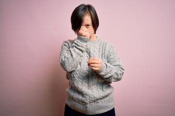 Sticker - Young down syndrome woman wearing casual sweater over isolated background tired rubbing nose and eyes feeling fatigue and headache. Stress and frustration concept.